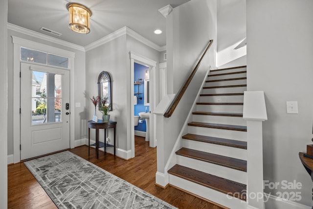 foyer featuring crown molding and dark hardwood / wood-style flooring