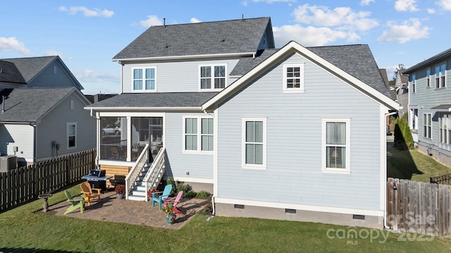 back of property with a lawn, a sunroom, and a patio