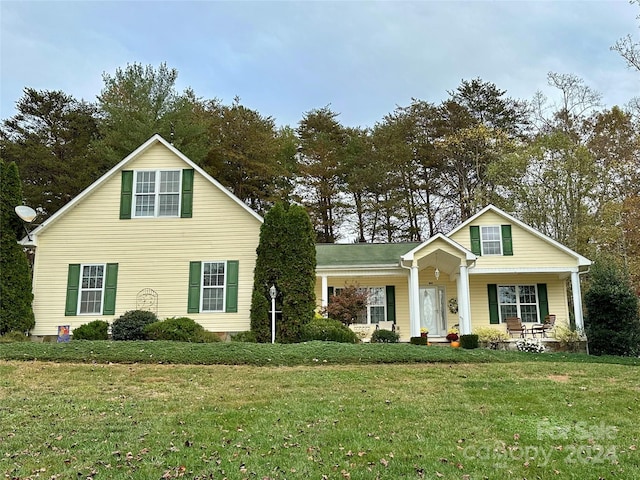 view of front of home with covered porch and a front lawn