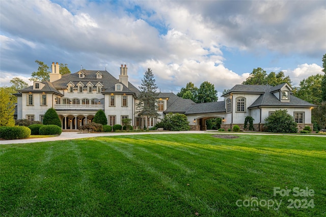 french country inspired facade with a front yard