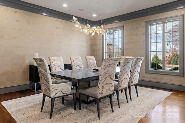 dining space with a chandelier, hardwood / wood-style flooring, and ornamental molding