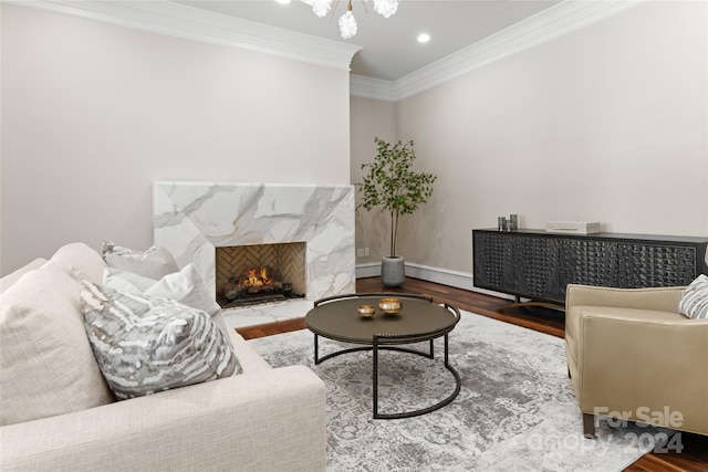 living room with hardwood / wood-style floors, a high end fireplace, and crown molding