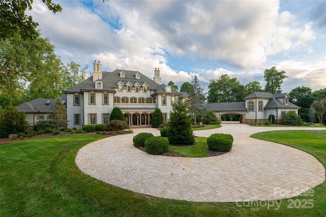 rear view of property featuring a garage and a lawn