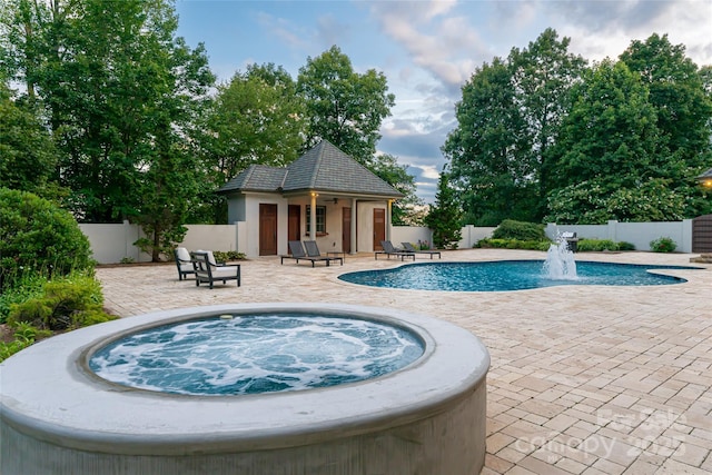 view of swimming pool with an outdoor hot tub, an outdoor structure, and a patio