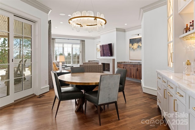 dining room featuring crown molding, a chandelier, and dark wood-type flooring