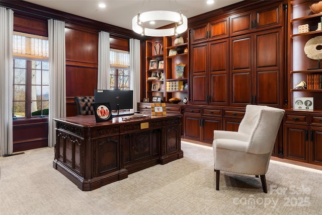 office area featuring a healthy amount of sunlight, light colored carpet, and built in shelves