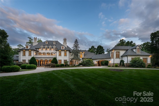 french country inspired facade featuring a lawn