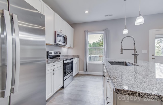 kitchen with a healthy amount of sunlight, stainless steel appliances, white cabinetry, and sink