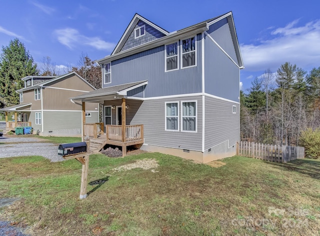 rear view of house featuring a porch and a lawn