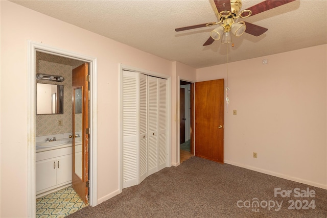 unfurnished bedroom with light carpet, sink, ceiling fan, a textured ceiling, and a closet