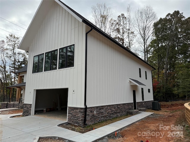 view of property exterior featuring central AC and a garage