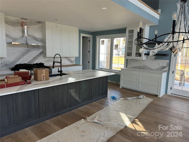 kitchen with white cabinets, decorative backsplash, and light hardwood / wood-style flooring