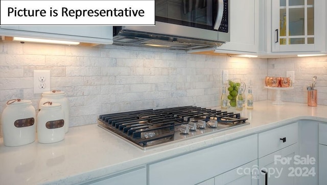 kitchen featuring appliances with stainless steel finishes, decorative backsplash, and white cabinets