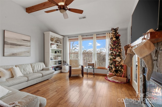 living room featuring ceiling fan, light hardwood / wood-style flooring, and lofted ceiling with beams