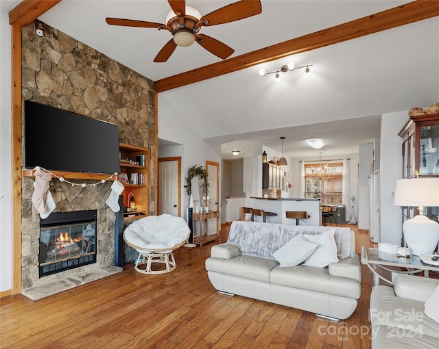 living room with a fireplace, wood-type flooring, vaulted ceiling with beams, and ceiling fan