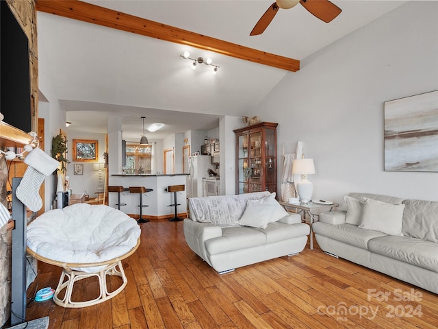 living room with vaulted ceiling with beams, ceiling fan, and light hardwood / wood-style floors