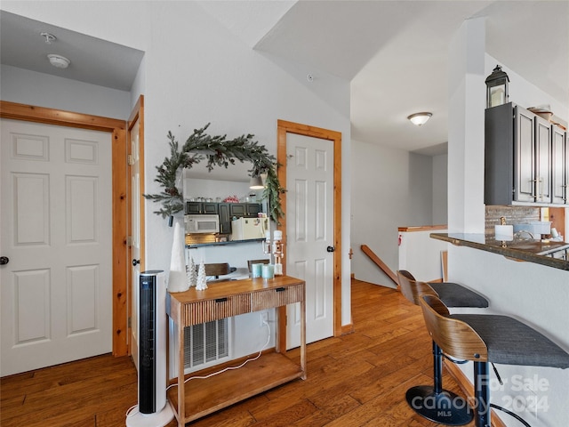 interior space with hardwood / wood-style floors, decorative backsplash, and white appliances