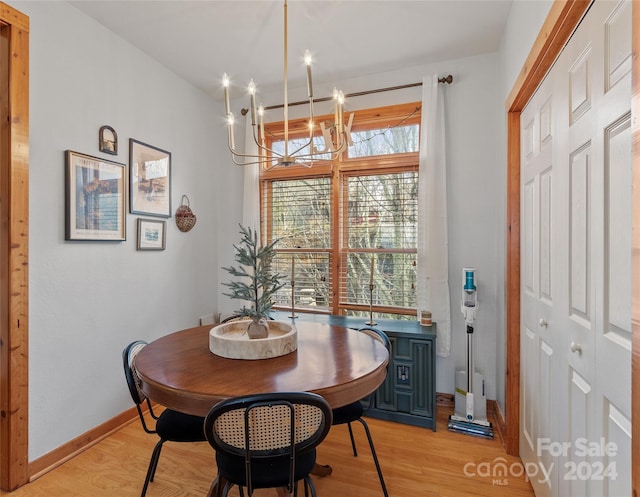 dining space with light hardwood / wood-style flooring and a chandelier