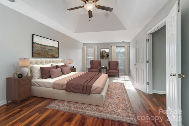 bedroom featuring ceiling fan, hardwood / wood-style floors, and a raised ceiling