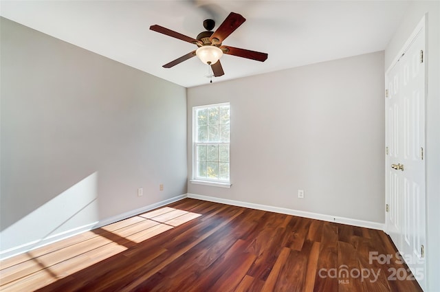 unfurnished room featuring dark wood-type flooring and ceiling fan