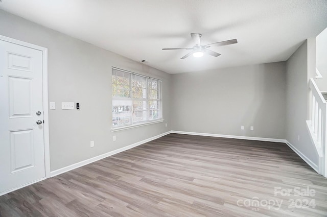 empty room with ceiling fan and light wood-type flooring