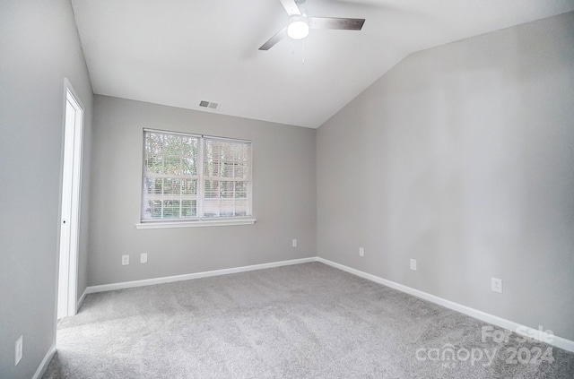 spare room with ceiling fan, light colored carpet, and lofted ceiling