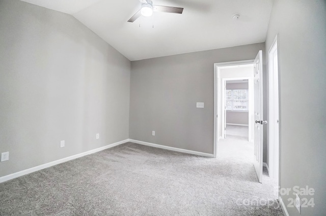 spare room featuring light carpet, ceiling fan, and lofted ceiling