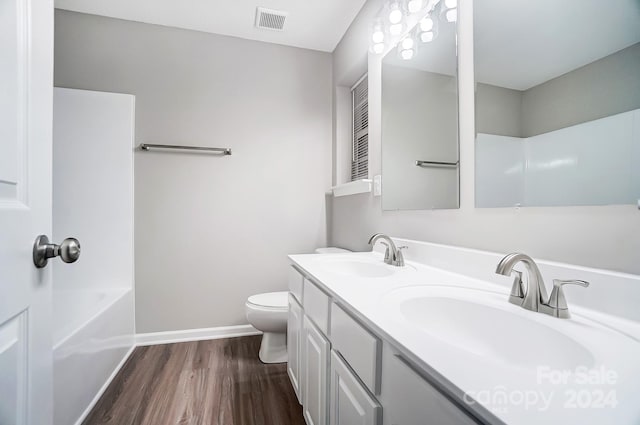 full bathroom featuring hardwood / wood-style flooring, vanity,  shower combination, and toilet