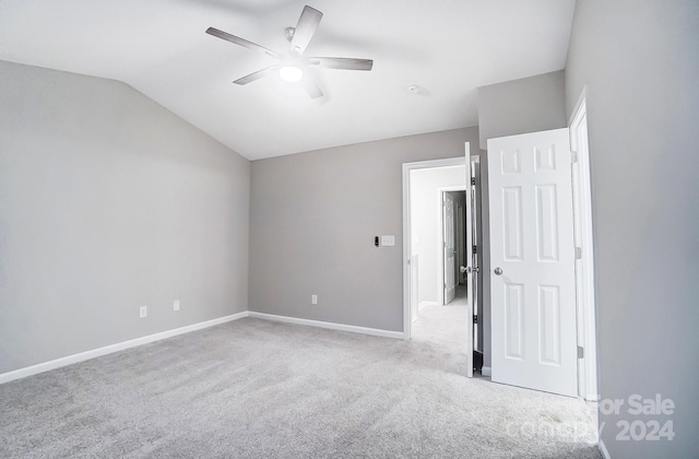 empty room featuring light carpet, vaulted ceiling, and ceiling fan