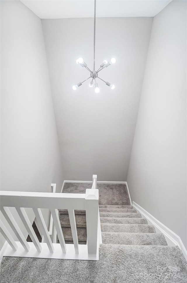 stairs featuring carpet flooring and a notable chandelier