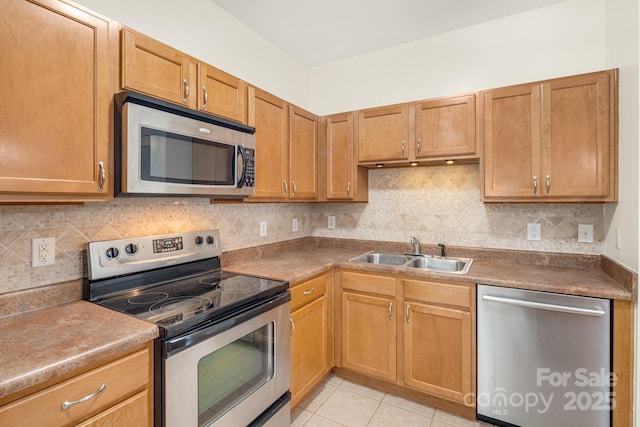 kitchen featuring decorative backsplash, sink, light tile patterned floors, and stainless steel appliances