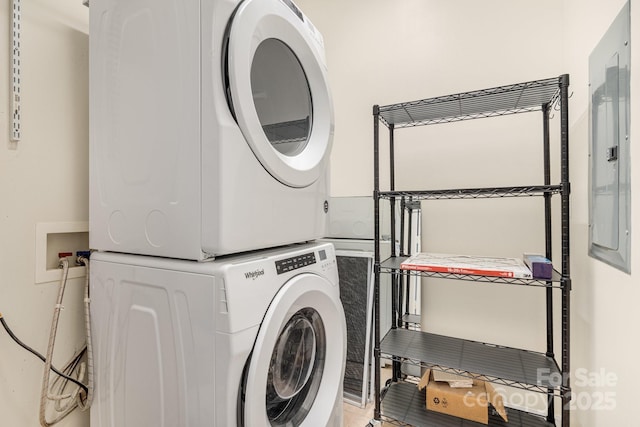 clothes washing area featuring stacked washer and clothes dryer