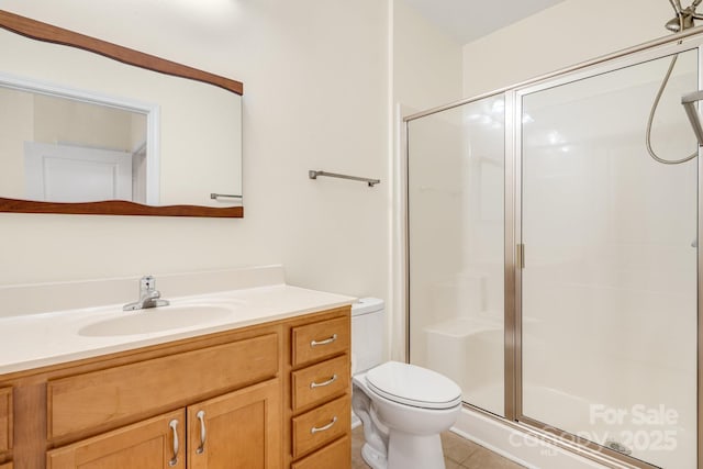 bathroom with tile patterned flooring, vanity, toilet, and a shower with shower door