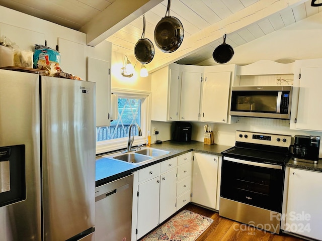 kitchen featuring white cabinetry, sink, appliances with stainless steel finishes, beam ceiling, and dark hardwood / wood-style flooring