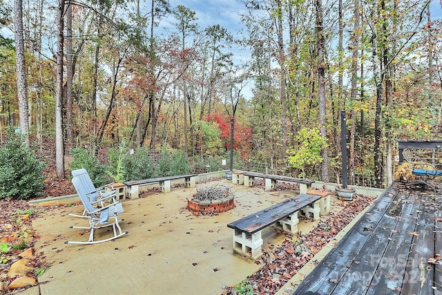 view of patio featuring a wooden deck and a fire pit