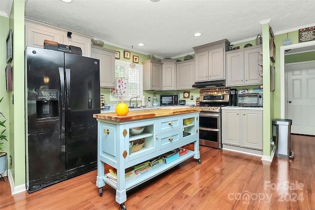 kitchen featuring stainless steel electric range oven, light hardwood / wood-style flooring, crown molding, wood counters, and black fridge with ice dispenser