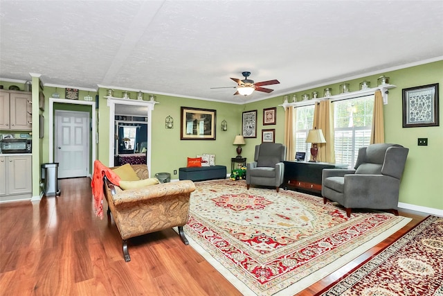 living room with ornamental molding, hardwood / wood-style floors, ceiling fan, and a textured ceiling