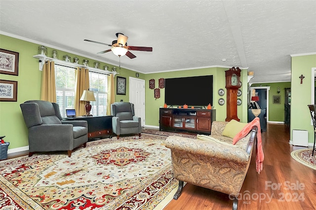 living room featuring a textured ceiling, ornamental molding, dark hardwood / wood-style floors, and ceiling fan