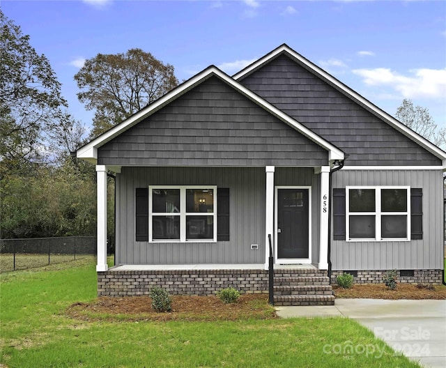 view of front of property with covered porch and a front yard