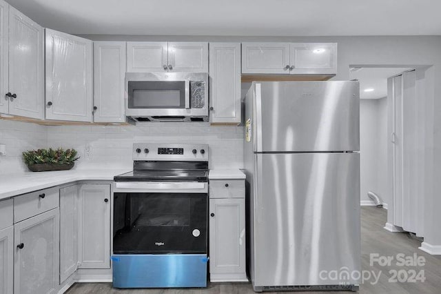 kitchen with light hardwood / wood-style floors, white cabinetry, stainless steel appliances, and tasteful backsplash