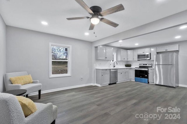 kitchen with ceiling fan, sink, dark hardwood / wood-style floors, decorative backsplash, and appliances with stainless steel finishes