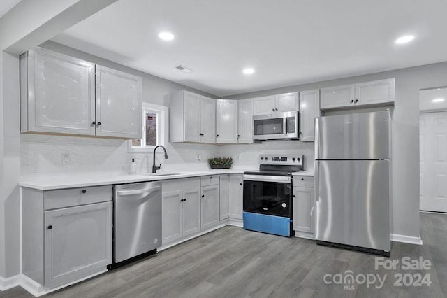 kitchen with backsplash, white cabinetry, sink, and appliances with stainless steel finishes