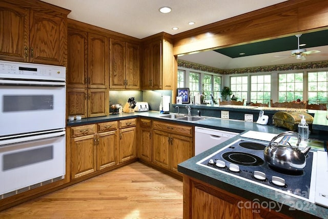 kitchen with ceiling fan, sink, white appliances, and light hardwood / wood-style flooring