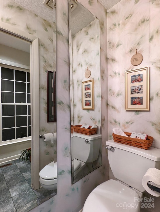 bathroom with a textured ceiling and toilet