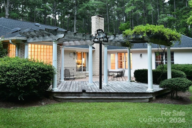 back of property featuring a pergola and a wooden deck