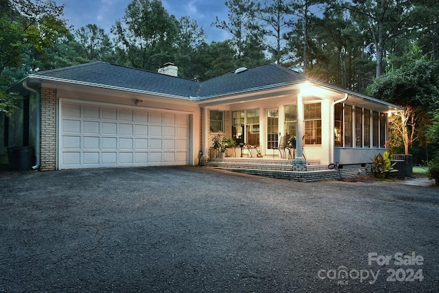 ranch-style home featuring a garage and central air condition unit