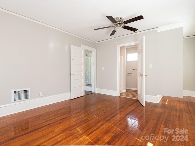 empty room featuring ceiling fan, wood-type flooring, and crown molding