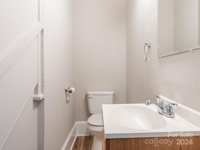 bathroom with hardwood / wood-style floors, vanity, and toilet