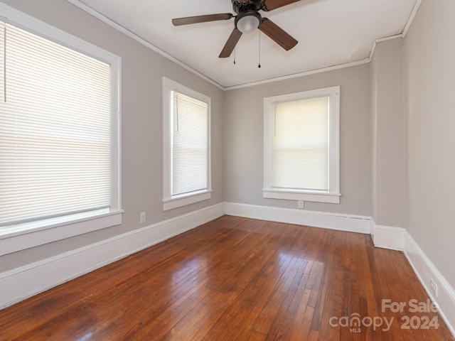 unfurnished room featuring plenty of natural light, ceiling fan, dark hardwood / wood-style flooring, and crown molding