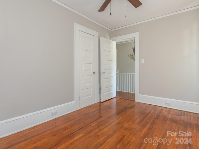 empty room featuring ceiling fan, hardwood / wood-style floors, and ornamental molding